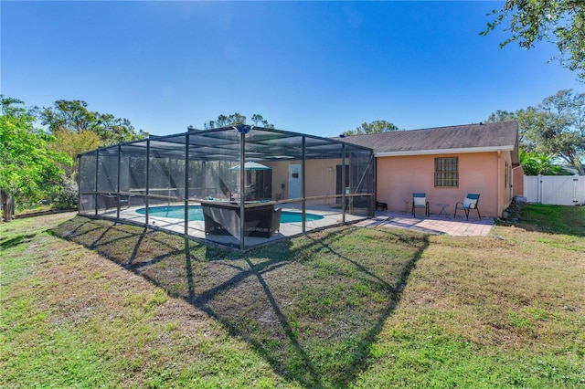 back of property with a lawn, glass enclosure, and a patio area