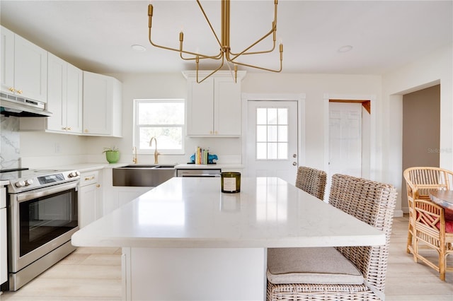 kitchen with white cabinets, a center island, electric range, and a kitchen bar