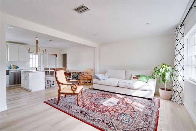 living room featuring a chandelier and light hardwood / wood-style floors