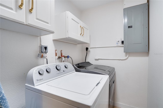 washroom featuring cabinets, washing machine and clothes dryer, and electric panel