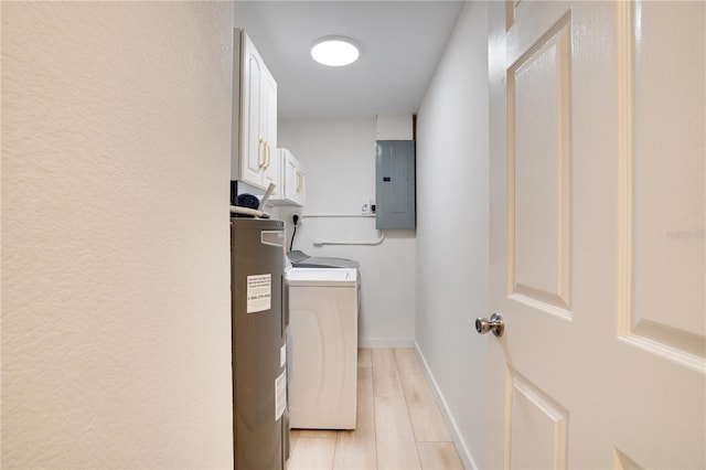 laundry area featuring washer and dryer, water heater, cabinets, electric panel, and light hardwood / wood-style floors