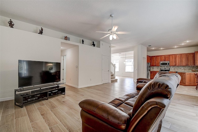 living room with ceiling fan and light wood-type flooring