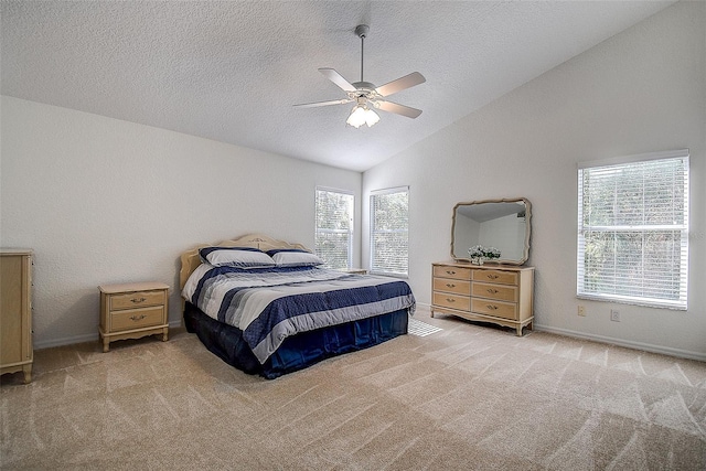 carpeted bedroom with multiple windows, a textured ceiling, vaulted ceiling, and ceiling fan