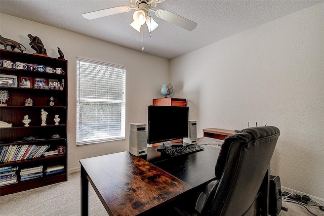 home office featuring a wealth of natural light, ceiling fan, light colored carpet, and a textured ceiling