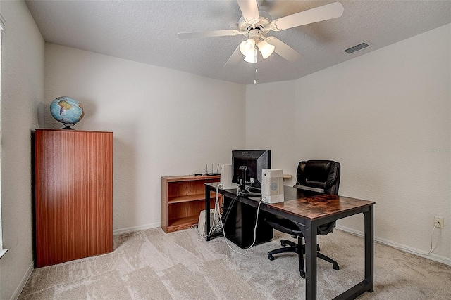 office area featuring light carpet, ceiling fan, and a textured ceiling