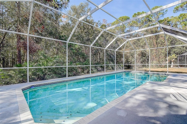 view of swimming pool with glass enclosure and a patio