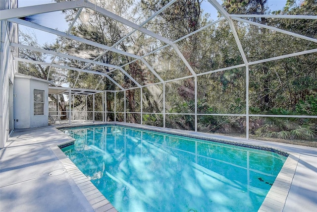 view of swimming pool with glass enclosure and a patio area