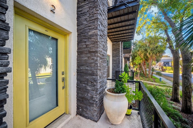 view of exterior entry featuring a balcony