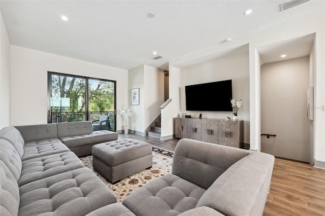 living room featuring a textured ceiling and light wood-type flooring