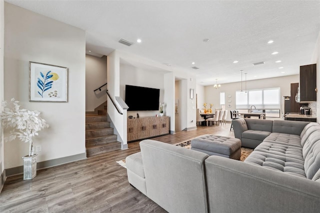 living room with a textured ceiling and light wood-type flooring