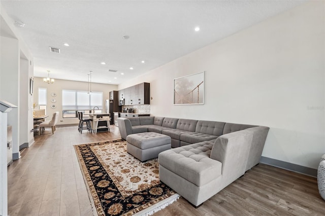 living room featuring a notable chandelier and wood-type flooring