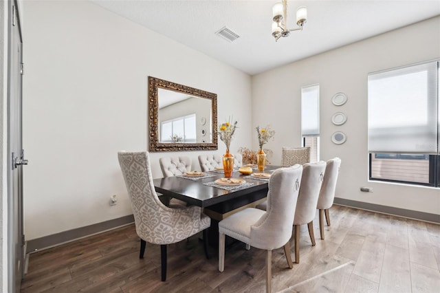 dining room featuring wood-type flooring and a notable chandelier