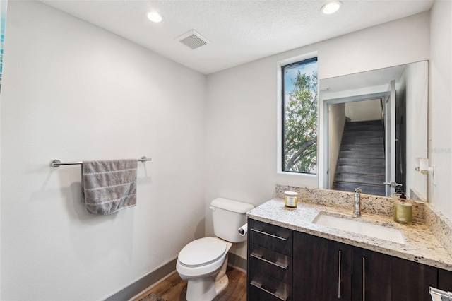 bathroom featuring hardwood / wood-style floors, vanity, toilet, and a healthy amount of sunlight