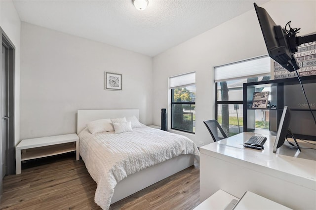 bedroom with dark hardwood / wood-style flooring and a textured ceiling