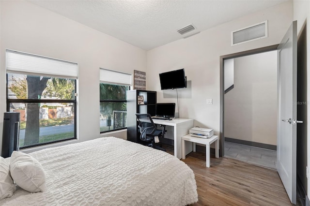 bedroom featuring hardwood / wood-style floors and a textured ceiling