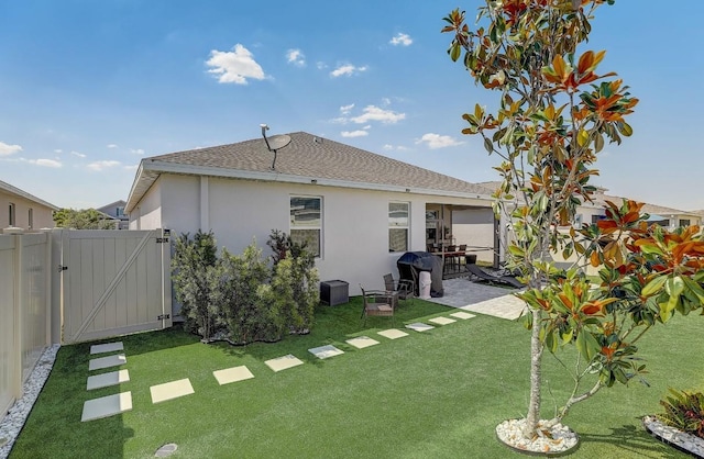 rear view of house with a patio and a lawn