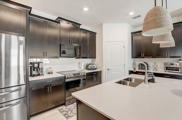 kitchen featuring decorative light fixtures, sink, dark brown cabinetry, and stainless steel appliances