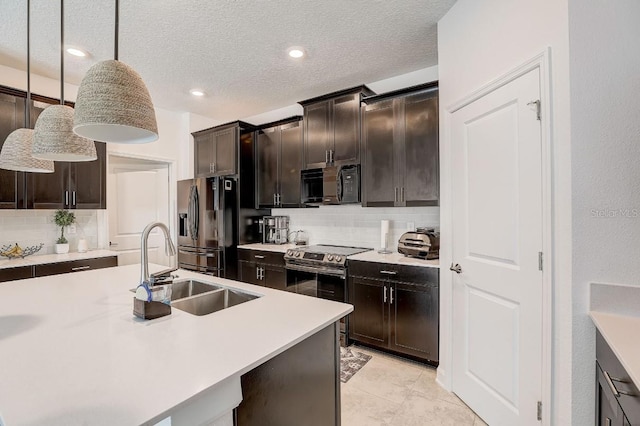 kitchen with appliances with stainless steel finishes, decorative light fixtures, a center island with sink, and sink