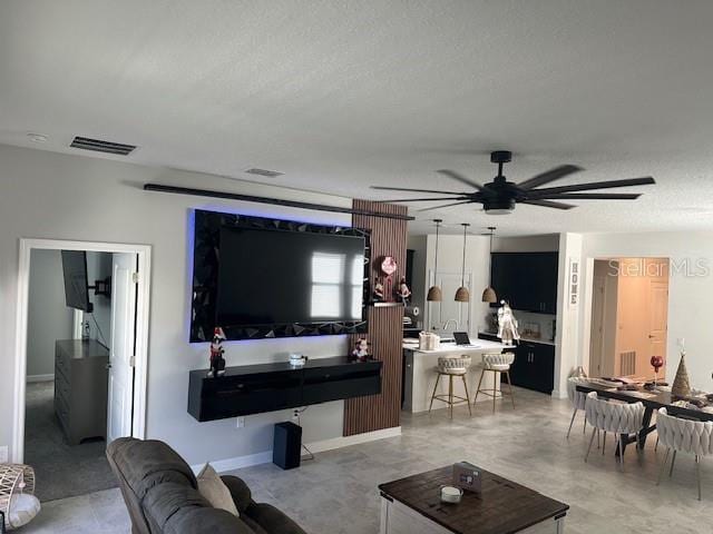 living room with a textured ceiling and ceiling fan