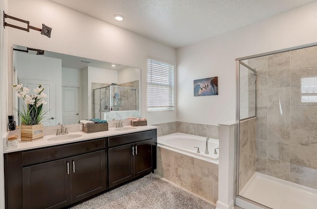 bathroom with vanity, independent shower and bath, and a textured ceiling