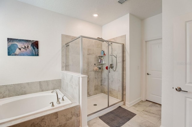 bathroom with a textured ceiling and independent shower and bath