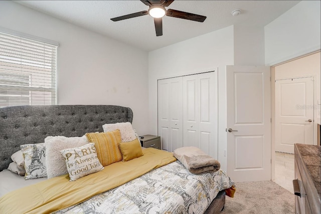 carpeted bedroom featuring ceiling fan and a closet