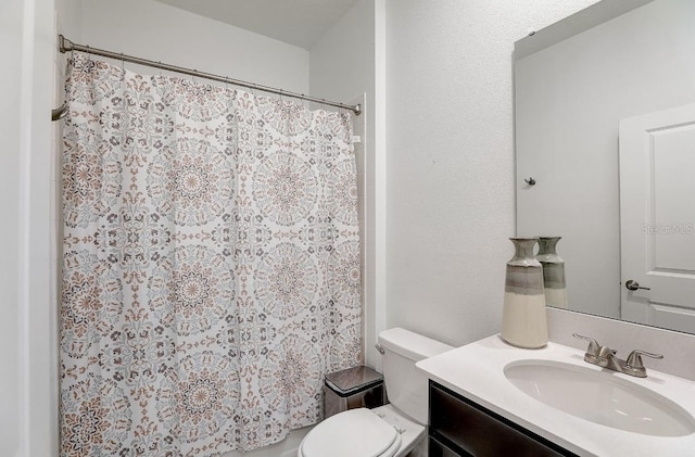 bathroom featuring a shower with shower curtain, vanity, and toilet