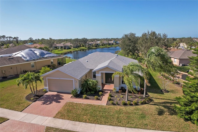 view of front of home featuring a water view, a front lawn, and a garage