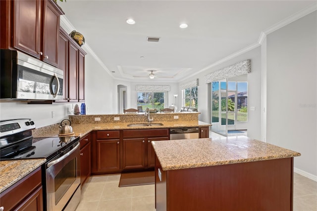 kitchen featuring light stone countertops, stainless steel appliances, sink, light tile patterned floors, and a center island