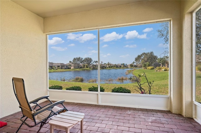 unfurnished sunroom featuring a water view