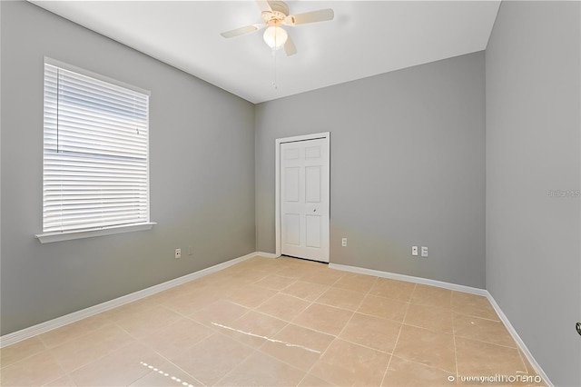 spare room with ceiling fan and light tile patterned floors