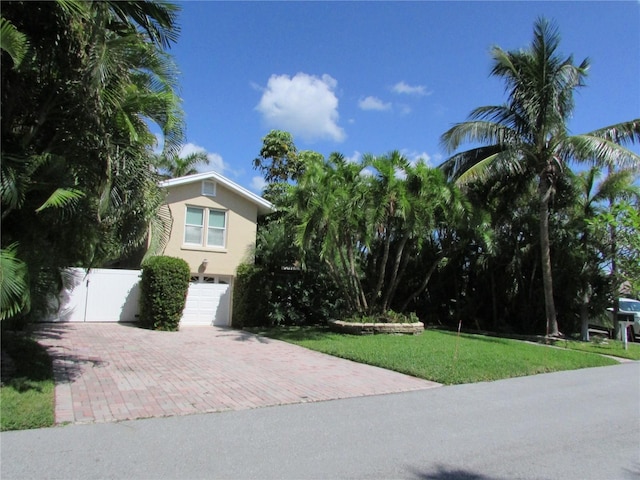 view of front of home featuring a front lawn and a garage