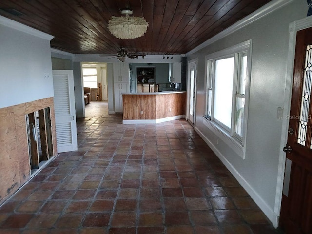 kitchen with wood ceiling, kitchen peninsula, a wealth of natural light, and ornamental molding