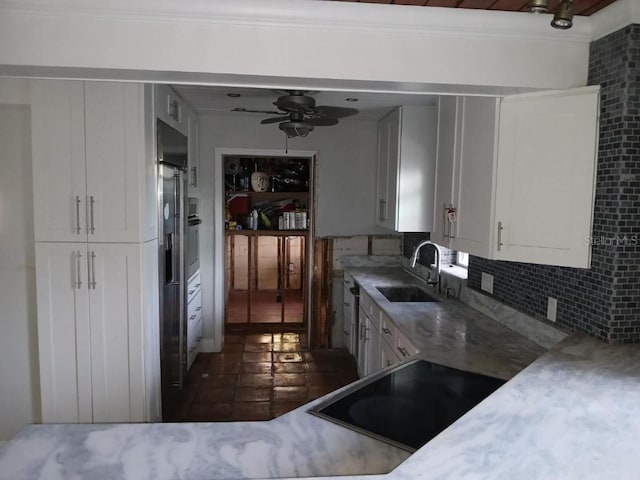 kitchen featuring backsplash, crown molding, sink, and white cabinets