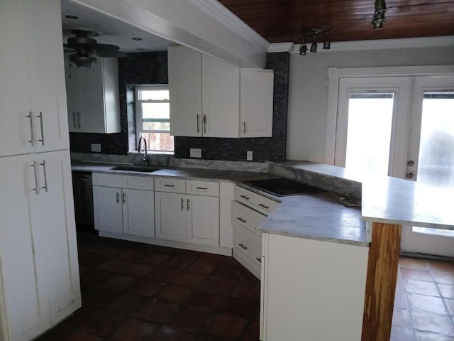 kitchen with backsplash, kitchen peninsula, white cabinetry, and sink