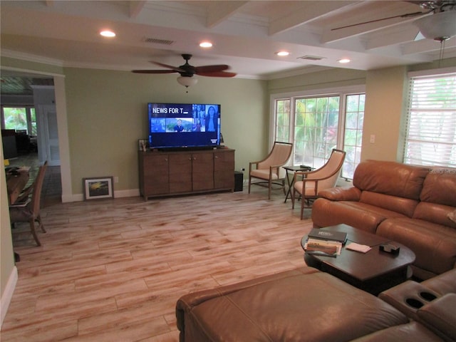 living room featuring beam ceiling, light hardwood / wood-style floors, a healthy amount of sunlight, and ornamental molding