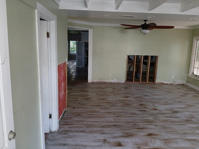 unfurnished room with ceiling fan, beamed ceiling, ornamental molding, and hardwood / wood-style flooring