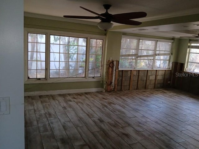 spare room featuring wood-type flooring, ceiling fan, and crown molding