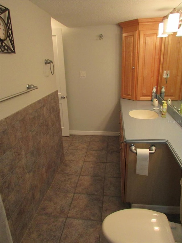 bathroom featuring tile patterned flooring, vanity, toilet, and a textured ceiling