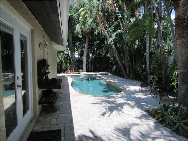 view of pool featuring a jacuzzi and a patio