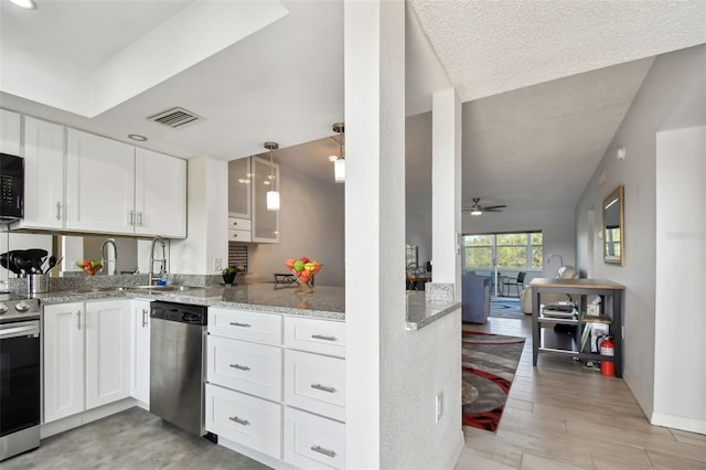 kitchen with light stone countertops, ceiling fan, stainless steel appliances, kitchen peninsula, and white cabinets