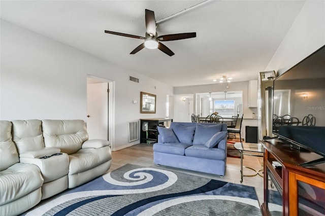 living room featuring light wood-type flooring and ceiling fan