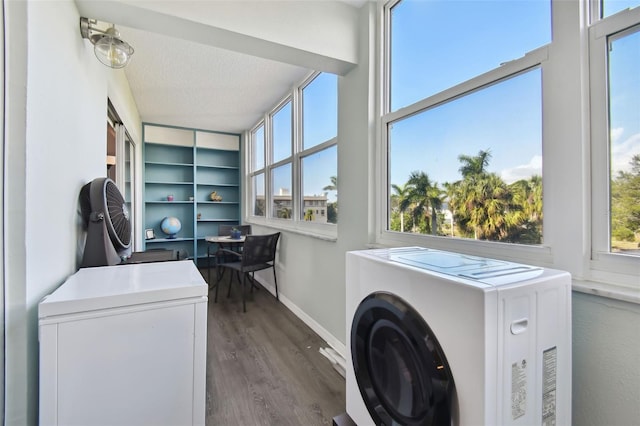 laundry room with a textured ceiling and dark wood-type flooring