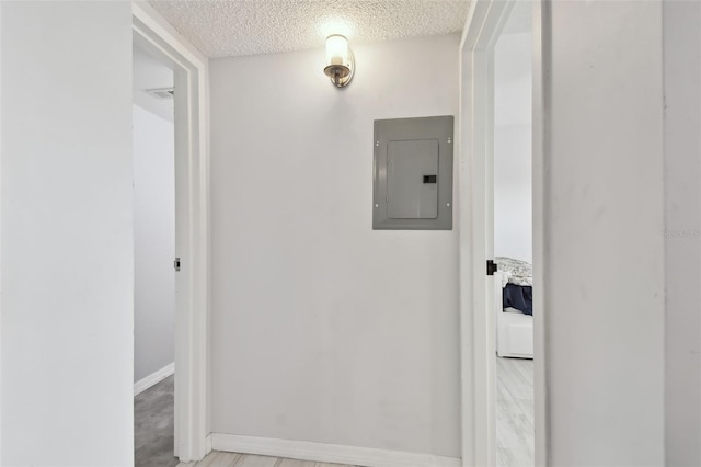 hallway with a textured ceiling and electric panel