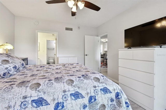 bedroom with ceiling fan, light wood-type flooring, and ensuite bath