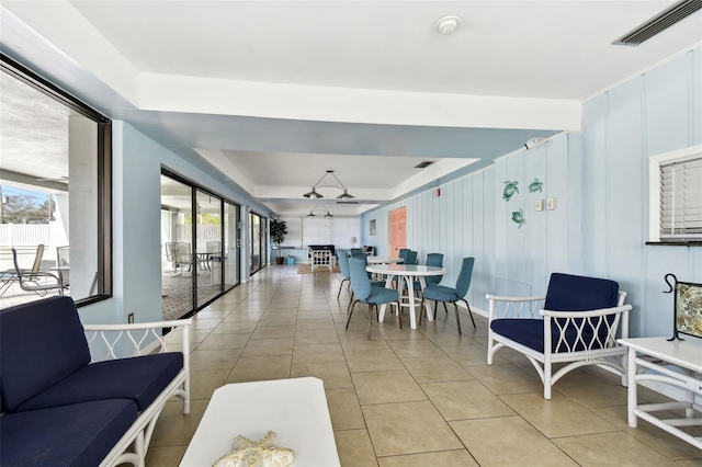 tiled dining space with a tray ceiling