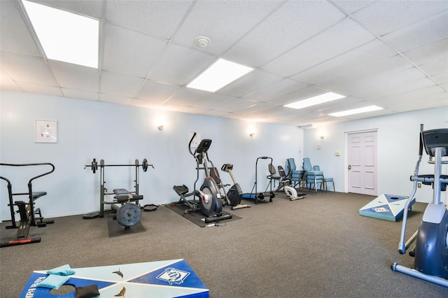 gym with a paneled ceiling and carpet floors