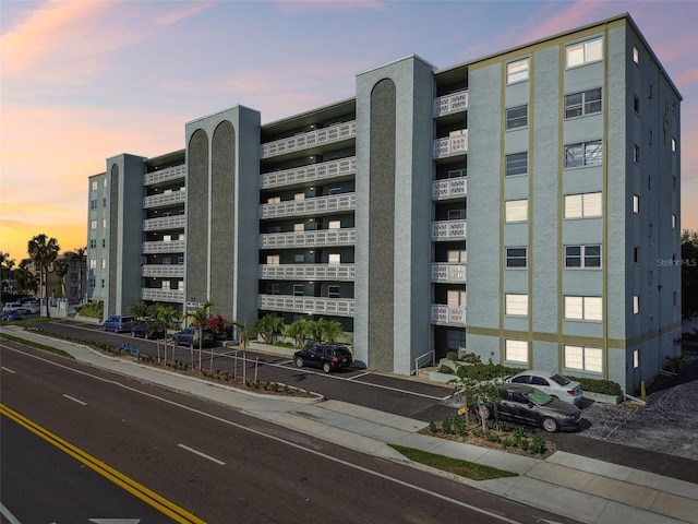 property at dusk featuring uncovered parking