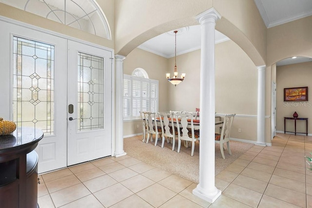 carpeted entrance foyer featuring ornamental molding, a wealth of natural light, and an inviting chandelier