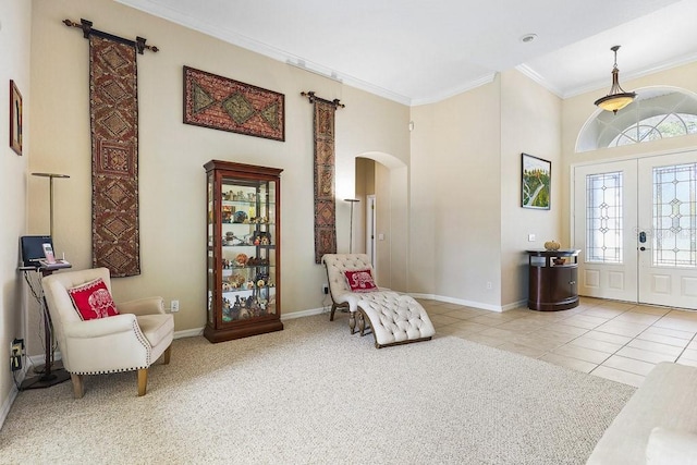 living area with plenty of natural light, light tile patterned flooring, ornamental molding, and french doors